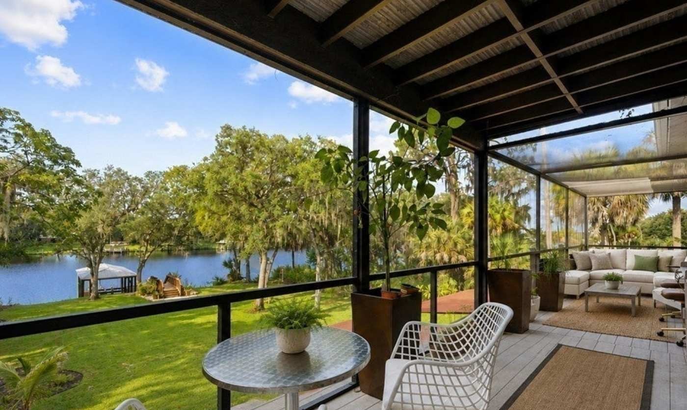 Screened outdoor living overlooking the landscaped riverfront grounds