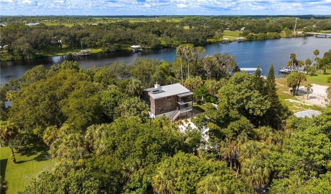 Aerial view of the home among trees beside the river