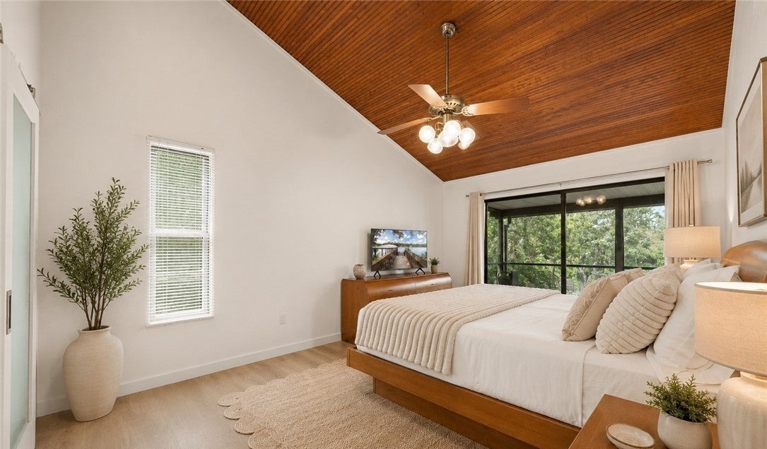 Bedroom with a warm wood ceiling above the bed